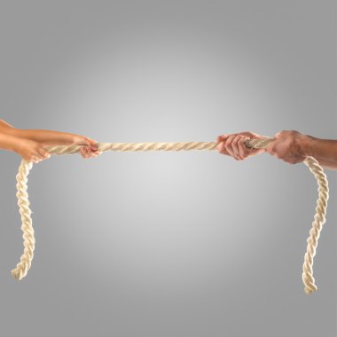 Gri bir arka plan üzerinde ip çekerek insanların elinde. Rekabet kavramı