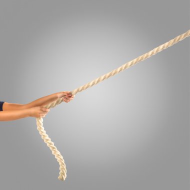 Gri bir arka plan üzerinde ip çekerek insanların elinde. İşbirliği kavramı