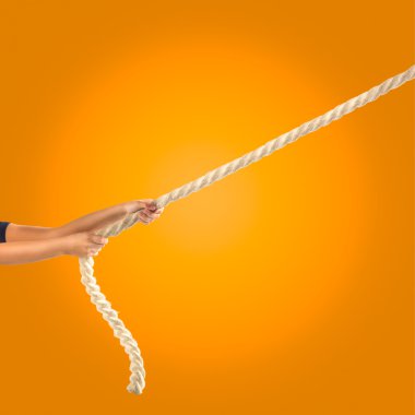 İpi turuncu zemin üzerine çekerek insanların elinde. Rekabet kavramı