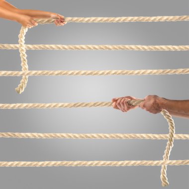 Gri bir arka plan üzerinde ip çekerek insanların elinde. Rekabet kavramı