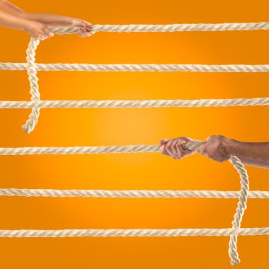 İpi turuncu zemin üzerine çekerek insanların elinde. Rekabet kavramı