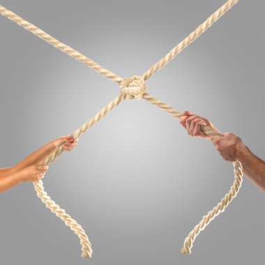 Gri bir arka plan üzerinde ip çekerek insanların elinde. Rekabet kavramı