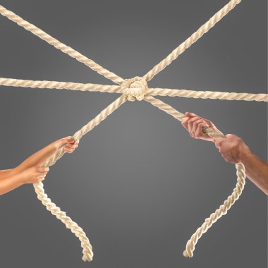 Siyah arka plan üzerine ip çekerek insanların elinde. Rekabet kavramı