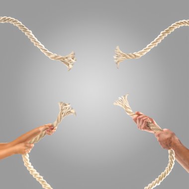 Gri bir arka plan üzerinde ip çekerek insanların elinde. Rekabet kavramı