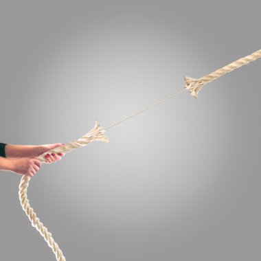 Gri bir arka plan üzerinde ip çekerek insanların elinde. Rekabet kavramı