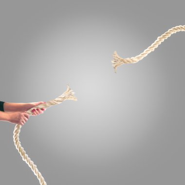 Gri bir arka plan üzerinde ip çekerek insanların elinde. Rekabet kavramı