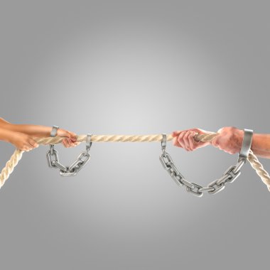 Ellerini kız ve yetişkin erkekler zincirleri gri bir arka plan üzerinde ip çekerek. Rekabet kavramı