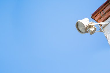 Cilt payı ve projektör ile evinin köşesindeki arka plan mavi gökyüzü üzerinde