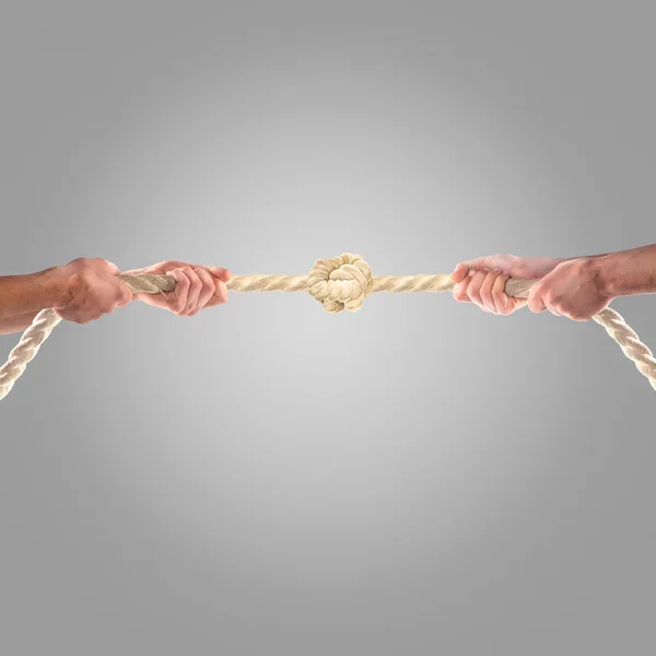 Hands of people pulling the rope on a gray background.  Competition concept — Stock Photo, Image