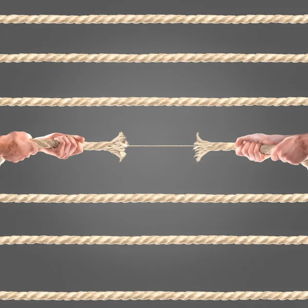 Hände von Menschen, die das Seil auf schwarzem Hintergrund ziehen. Wettbewerbskonzept — Stockfoto