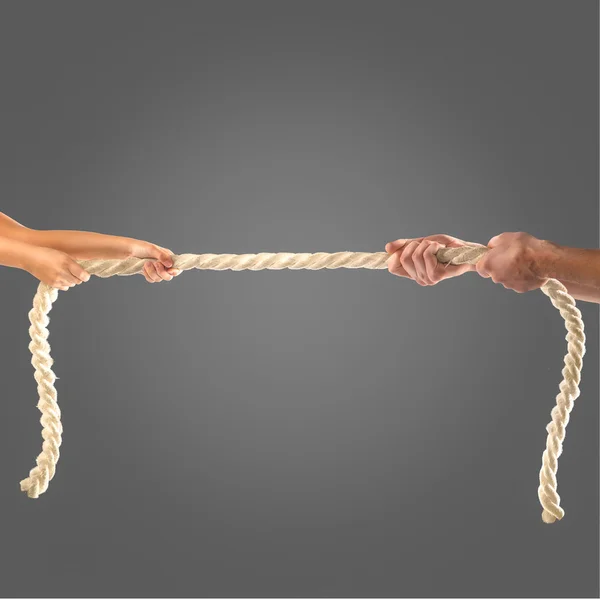 Hands of people pulling the rope on black background. Competition concept — Stock Photo, Image