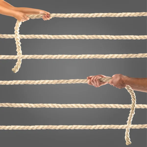 Siyah arka plan üzerine ip çekerek insanların elinde. Rekabet kavramı