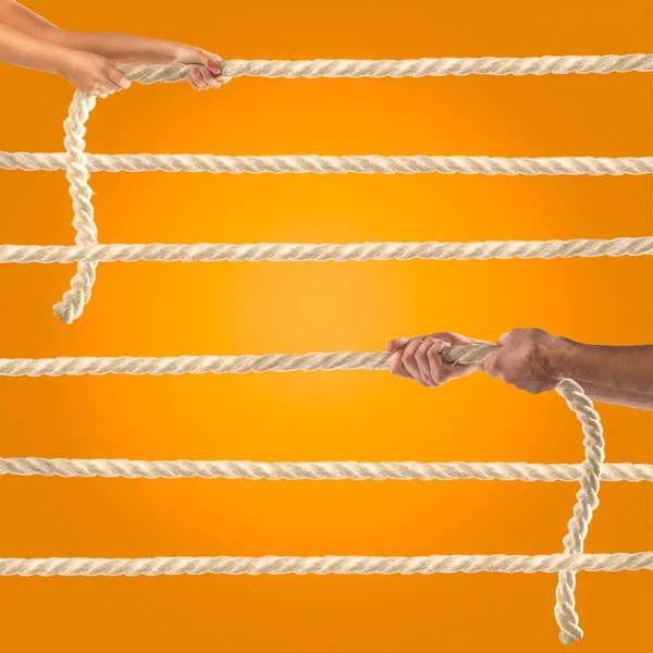 İpi turuncu zemin üzerine çekerek insanların elinde. Rekabet kavramı