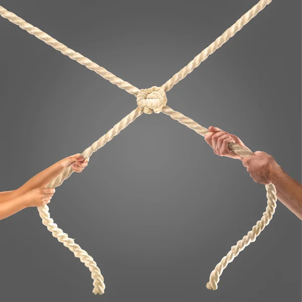 Hands of people pulling the rope on black background. Competition concept — Stock Photo, Image