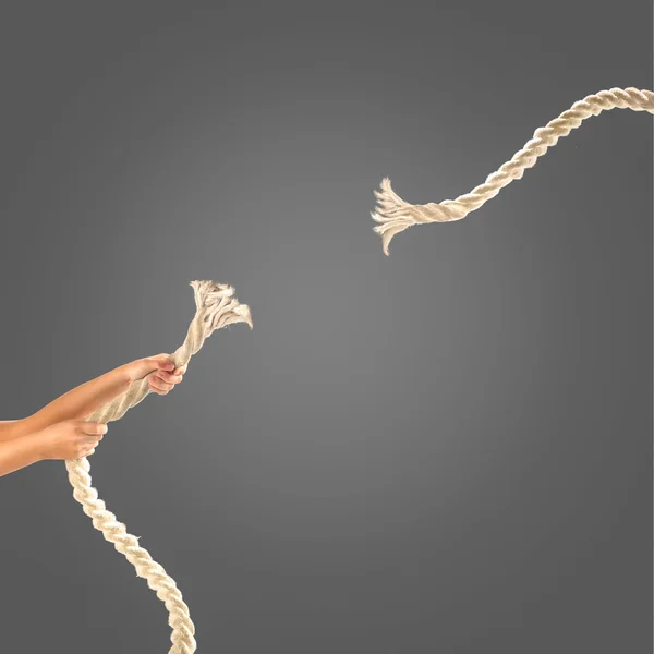 黒い背景にロープを引っ張る人の手。競争の概念 — ストック写真