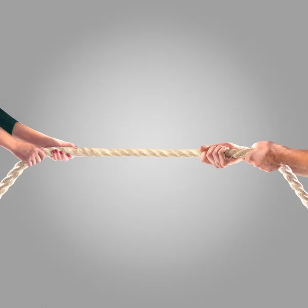 Hands of people pulling the rope on a gray background.  Competition concept — Stock Photo, Image