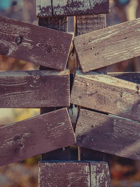 Primo piano di vecchie assi di legno recinzione sullo sfondo del giardino. Idea autunnale. Immagine filtrata — Foto Stock