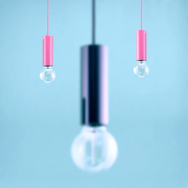 Decorative antique edison style filament light bulb on light blue background. Filtered image — Stock Photo, Image