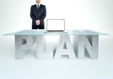 Confident business man standing near a PLAN table. Bussines concept