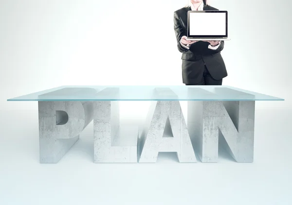 Confident business woman, standing near the PLAN table and holding a laptop. Bussines concept — 스톡 사진