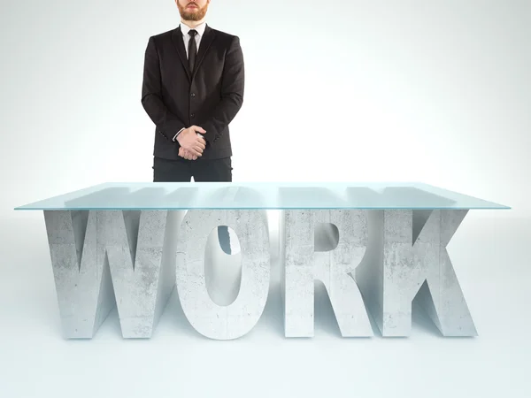 Un hombre de negocios seguro parado cerca de una mesa de trabajo. Concepto de empresas — Foto de Stock