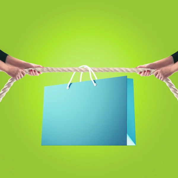 Hands of people pulling the rope on color background. Shopping concept — Stockfoto