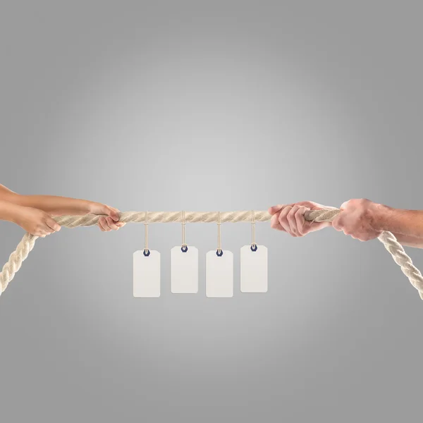 Hands of people pulling the rope on gray background. Shopping concept — Stockfoto
