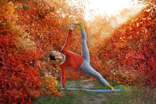 Woman practicing side plank yoga pose while aoutdoor training