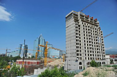 Almaty / Kazakistan - 07.02.2012: Şehir merkezindeki evlerin yoğun gelişimi: diğer nesnelere yakın bir konut kompleksinin inşası.