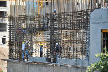 Almaty / Kazakistan - 07.02.2012: Evin şantiyesindeki işçiler beton bloklar için kaynak demiri ve tamiri ile meşgul