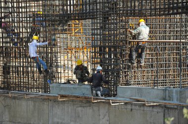 Almaty / Kazakistan - 07.02.2012: Evin şantiyesindeki işçiler beton bloklar için kaynak demiri ve tamiri ile meşgul