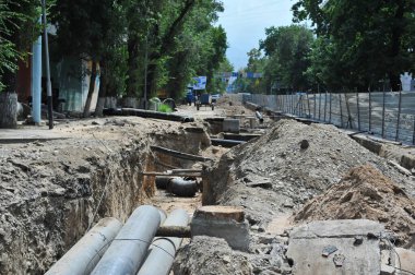 Almaty / Kazakistan - 08.14.2012: Karayolu merkezindeki su ve ısıtma borularının onarımı ve değiştirilmesi.