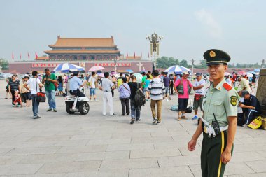 Pekin / Çin - 08.06.2012: Bir güvenlik görevlisi Tiananmen Meydanı 'ndan geçiyor