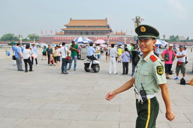 Pekin / Çin - 08.06.2012: Bir güvenlik görevlisi Tiananmen Meydanı 'ndan geçiyor