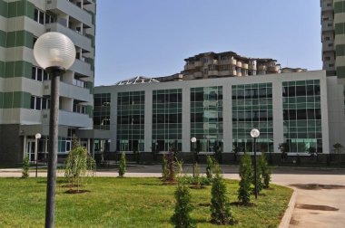 Almaty / Kazakistan - 09.10.2012: Konut kompleksinin bölgesi. Mavi-yeşil cam pencereli bir bina.