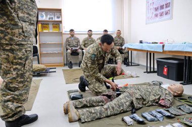 Almaty / Kazakistan - 11.20.2020: Bir asker kritik bir durum sırasında manken eylemlerini gösteriyor. Barış gücü müfrezesiyle tatbikat..