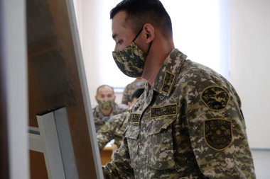 Almaty / Kazakistan - 11.20.2020: Bir asker tahtaya veri yazar. Bir müfreze barış gücüyle taktik tatbikatlar..