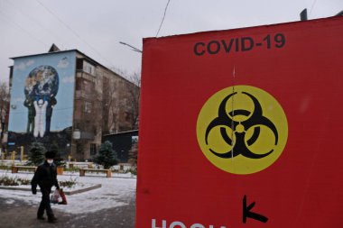 Almaty / Kazakistan - 11.20.2020: Şehrin sokaklarında enfeksiyon tehlikesi hakkında uyarısı olan kırmızı poster. Kar yağışıweather condition.