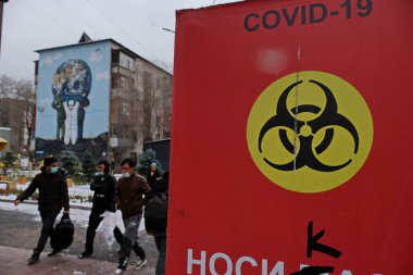 Almaty / Kazakistan - 11.20.2020: Şehrin sokaklarında enfeksiyon tehlikesi hakkında uyarısı olan kırmızı poster. Kar yağışıweather condition.
