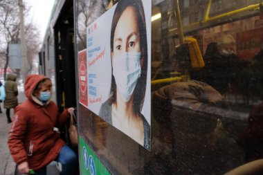Almaty / Kazakistan - 11.20.2020: Otobüsün camında bir poster: Maske takmak zorunludur. Yolcular araca binsin. Kar yağışıweather condition.