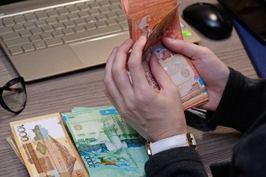 Almaty, Kazakistan - 12.01.2020: Ellerdeki farklı banknotların yeniden hesaplanması. Kazakistan 'ın para birimi tenge..