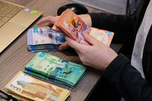 Almaty, Kazakistan - 12.01.2020: Ellerdeki farklı banknotların yeniden hesaplanması. Kazakistan 'ın para birimi tenge..