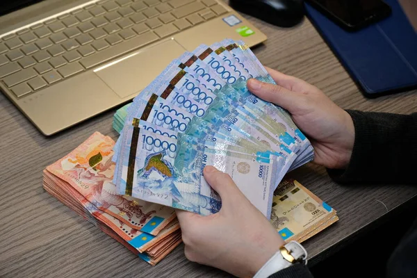 Almaty, Kazakistan - 12.01.2020: Kazakistan 'ın onluk banknotları bir vantilatörün ellerinde düzenlendi.