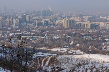 Almaty, Kazakistan - 11.30,2020: Almaty şehrindeki tepenin manzarası sis tabakalarıyla kaplı. Konut ve idari binalar.
