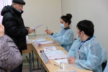 Almaty, Kazakistan - 01.10.2021: Vatandaşlar verilerini bir seçim komisyonu üyesiyle dolduruyorlar. Kazakistan 'da parlamento seçimleri