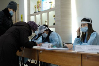 Almaty, Kazakistan - 01.10.2021: Vatandaşlar verilerini bir seçim komisyonu üyesiyle dolduruyorlar. Kazakistan 'da parlamento seçimleri