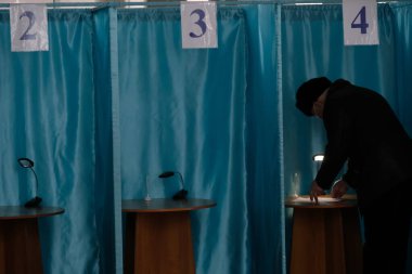 Almaty, Kazakistan - 01.10.2021: Vatandaşlar oy pusulalarını oy kabininde dolduruyorlar. Kazakistan 'da parlamento seçimleri