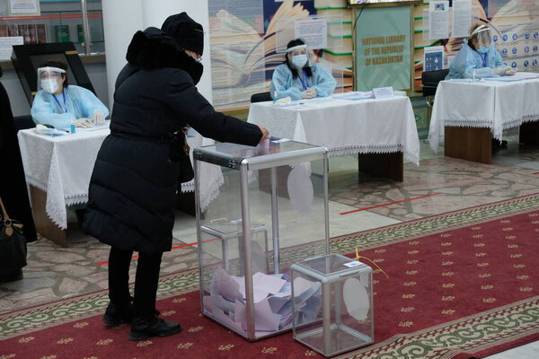 Алматы, Казахстан - 01.10.2021: Граждане вставляют бюллетени в урну для голосования. Парламентские выборы в Казахстане