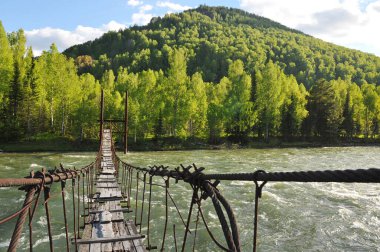 Ridder, Kazakistan - 06.05.2013: Köprü eski ahşap, metal çubuklar ve demirden yapılmıştır. Irtysh Nehri.