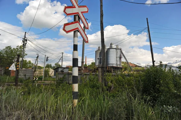 Ridder, Kazakistan - 06.05.2013: Köy bölgesinde demiryolu geçidi tabelası